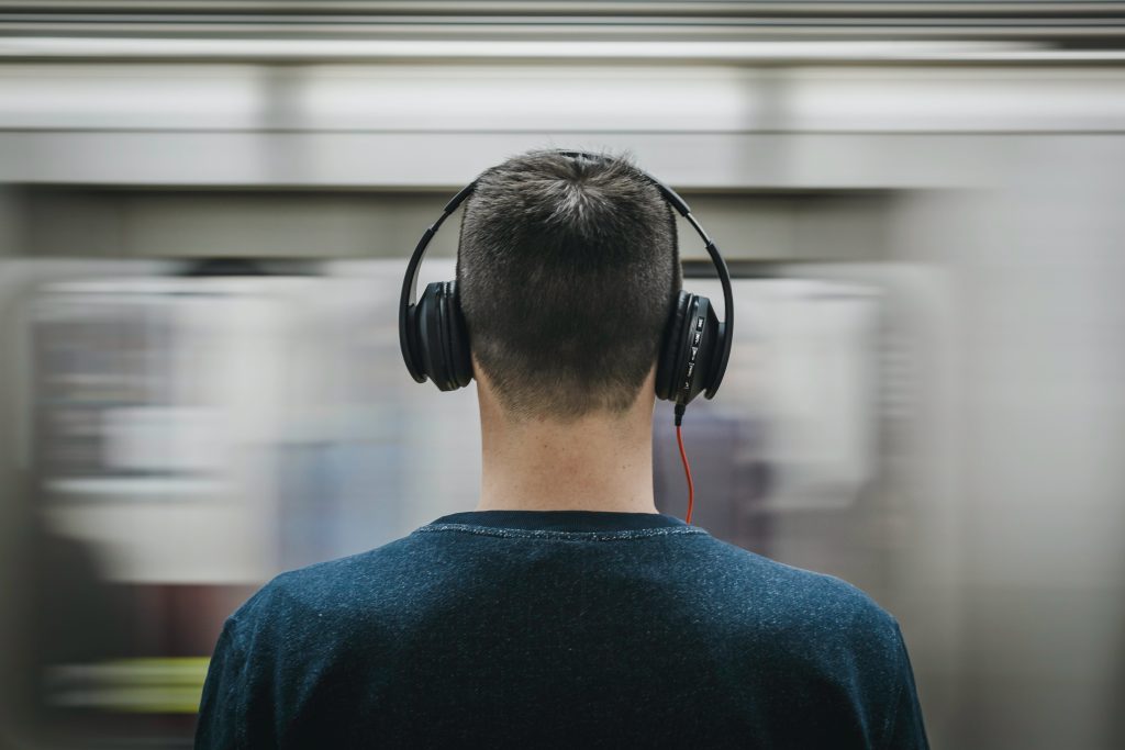 Uomo ascolta musica in cuffie. Nell'articolo di parla di audio 8D.